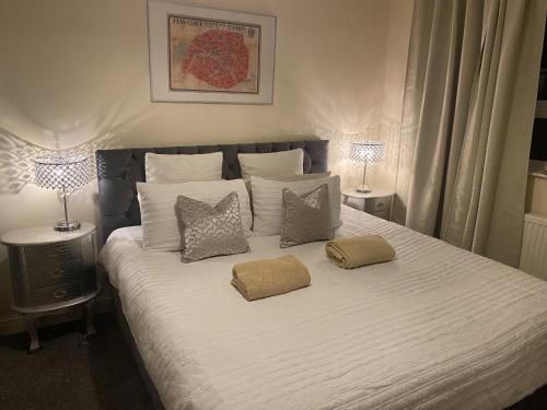 a bed with two pillows on it with two lamps at Stylish & Cosy Apartment in Bristol