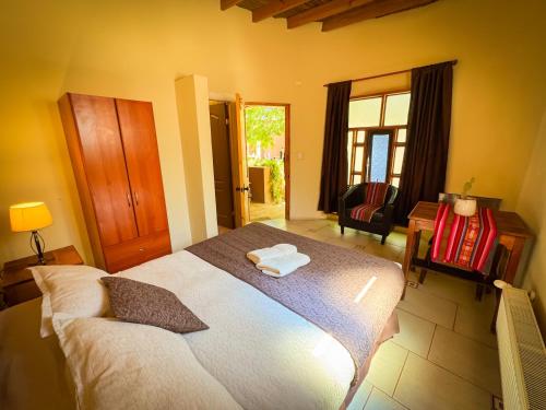 a bedroom with a large bed with two towels on it at Hostal y Cabañas Renta House San Pedro in San Pedro de Atacama