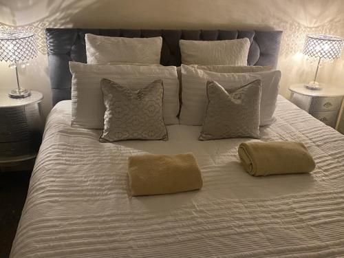 a large white bed with pillows on top of it at Stylish & Cosy Apartment in Bristol