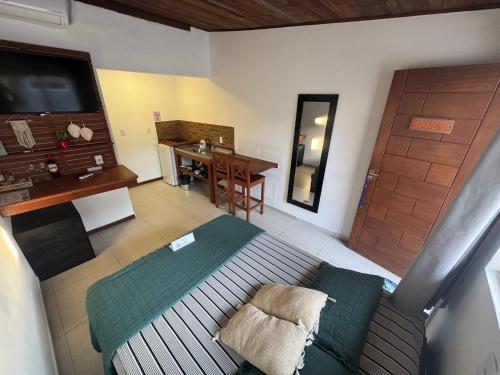 a room with a bed and a table and a desk at Pousada Ilha do Campeche in Florianópolis