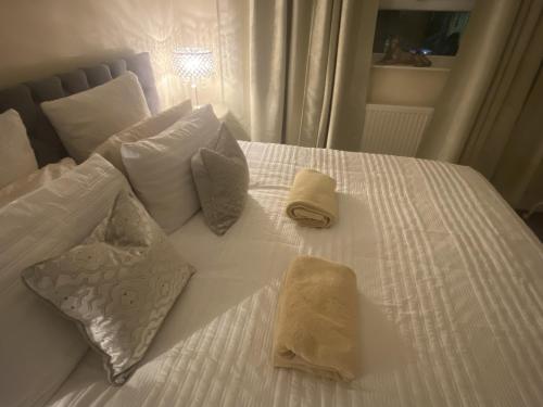 a white bed with two towels and pillows on it at Stylish & Cosy Apartment in Bristol
