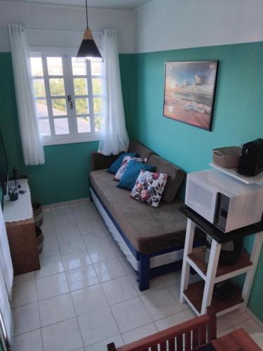a living room with a couch and a window at Brisa da Praia Residencial in Florianópolis