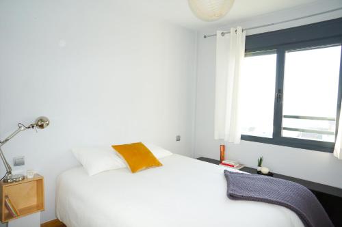 1 dormitorio con cama blanca y ventana en Apartamentos Madrid Anderson, en Madrid