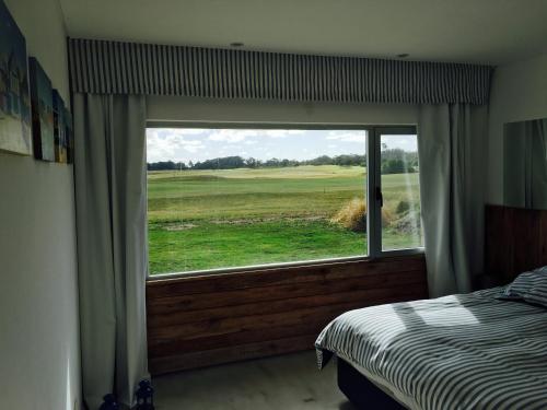 a bedroom with a window with a view of a golf course at Casa en Miramar Golf in Miramar