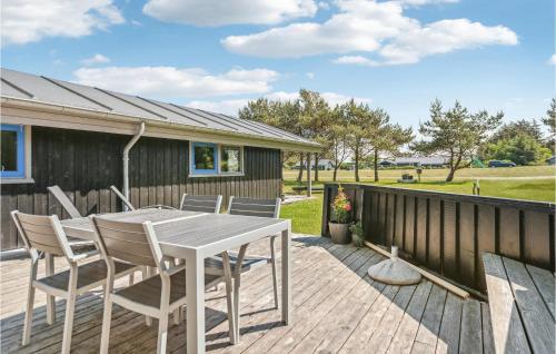 a patio with a table and chairs on a deck at Cozy Home In Hjørring With Sauna in Lønstrup