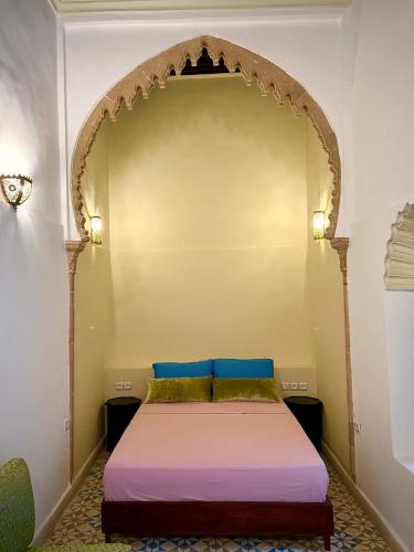 a bed in a room with an arch above it at Riad Dar Chaafa 17 in Salé