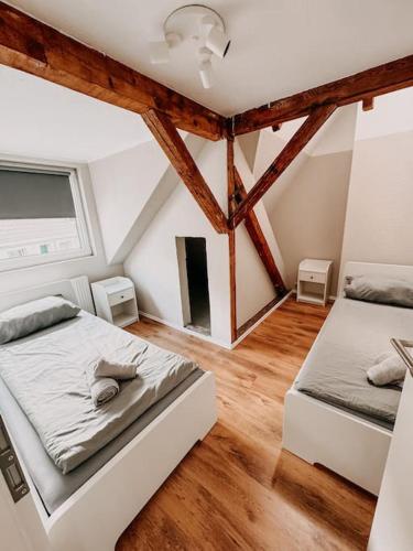 zwei Betten in einem Zimmer mit Holzboden in der Unterkunft Zentral in Essen! 5 Gehminuten vom Bahnhof ! WHDG in Essen