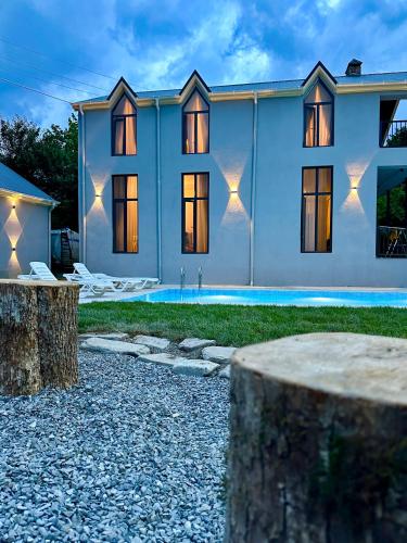 a house with a pool in front of it at Blueberryhouse in İsmayıllı