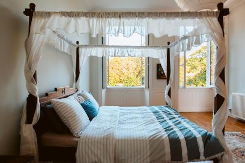 a bedroom with a canopy bed and a mirror at Château Chevreuil in Fresnay-en-Retz