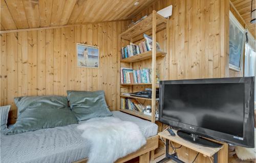 a living room with a large screen tv and a bed at Holiday Home Svenstibakkevej Ii in Lild Strand