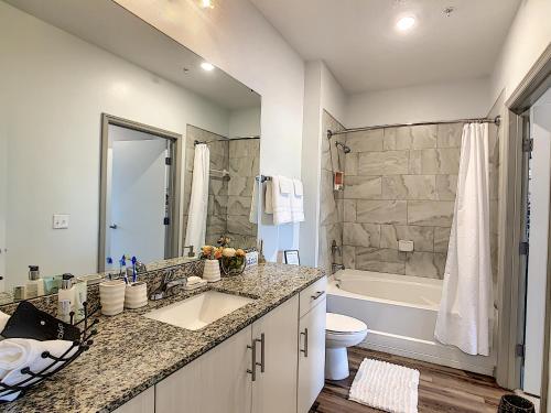a bathroom with a sink and a toilet and a tub at Convenient and Close to All in Kissimmee