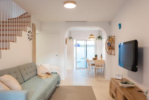 a living room with a couch and a tv at Casa dos Pescadores in Esposende