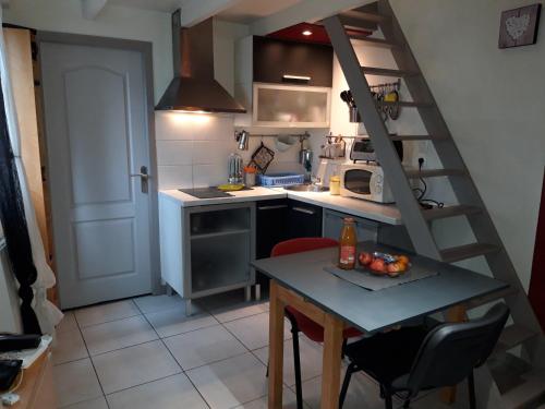une petite cuisine avec une table et un escalier dans l'établissement Petit maison avec jardin, à Roquettes