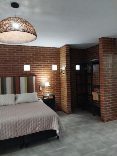 a bedroom with a bed and a brick wall at soy ahora 1 y 2 in Pueblito