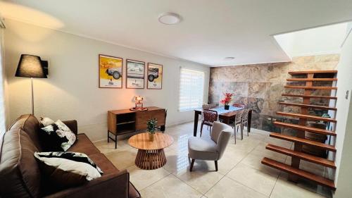 a living room with a couch and a table at Nogales House, by Pewma Apart Hotel in Chillán