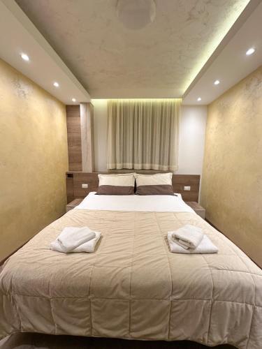 a bedroom with a large bed with two towels on it at MB Apartmani Kopaonik in Kopaonik