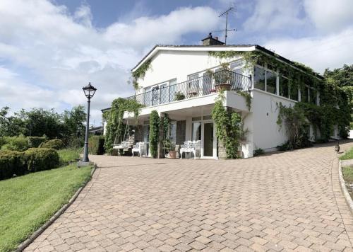 a white house with a brick driveway at Greenview House in Clones