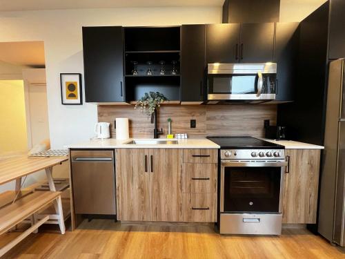 a kitchen with wooden cabinets and a sink and a stove at Luxe Urban Retreat, Unit 602 in Halifax