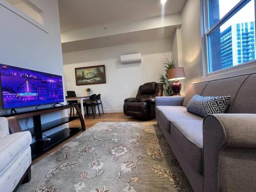 a living room with a couch and a flat screen tv at Urban Sophistication, Ocean View, Unit 513 in Halifax