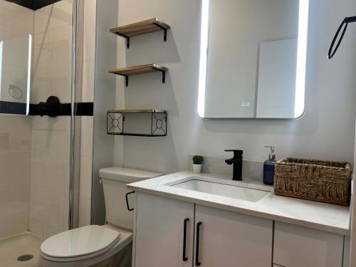 a white bathroom with a sink and a toilet at Urban Sophistication, Ocean View, Unit 513 in Halifax