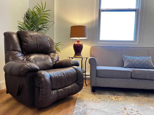 a leather chair and a couch in a living room at Urban Sophistication, Ocean View, Unit 513 in Halifax