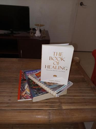 a book sitting on top of books on a table at La Casa Alemanya in Moalboal