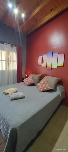 a bedroom with a large bed with red walls at La Arcadia in Mina Clavero