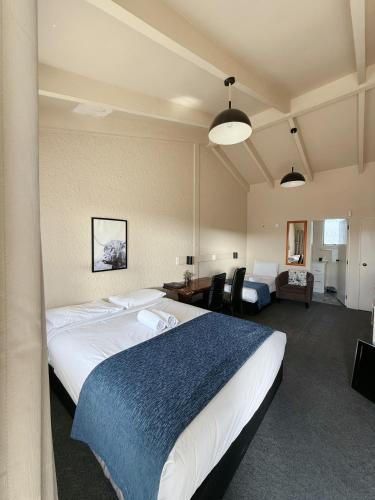 a hotel room with two beds and a living room at Cortez Motel in Whakatane