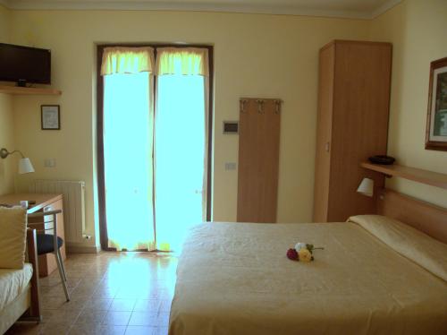 a bedroom with a bed with a teddy bear on it at Hotel Il Caminetto in Portoferraio
