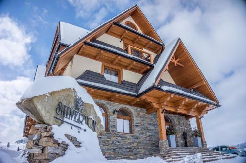 a house on top of a mountain in the snow at Silverton -sauna,jacuzzi,mini siłownia,bar sezonowy, przyjazny rodzinom in Białka Tatrzanska