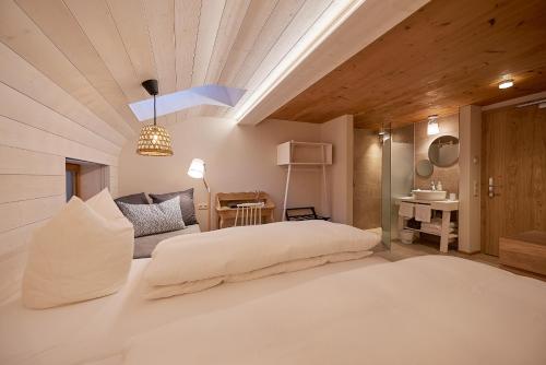 a bedroom with a large white bed in a room at Hotel Rössle in Au im Bregenzerwald