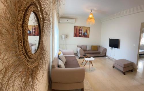 a living room with a couch and a mirror at Appartement top capi in La Marsa