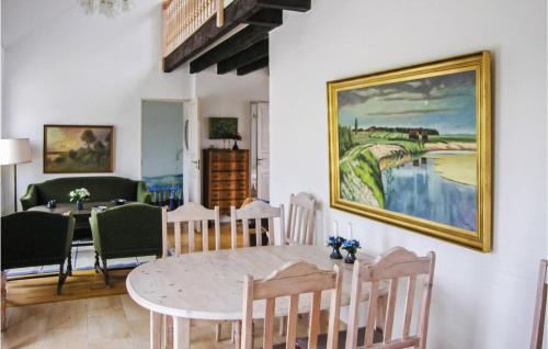 a dining room with a table and a painting on the wall at Holiday Home Bakkegårdsvej in Arup