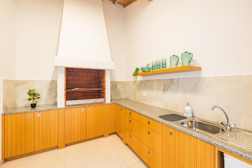 a kitchen with wooden cabinets and a sink at The Islet Retreat in Vila Franca do Campo