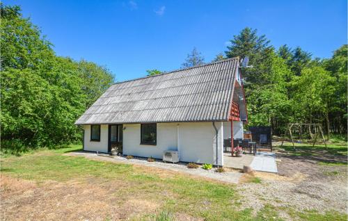 a small white house in the middle of a field at Cozy Home In Øster Assels With Sauna in Øster Assels