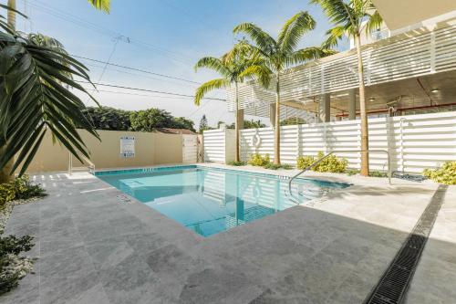 a swimming pool with palm trees and a building at MONROE APART HOTEl in Hollywood