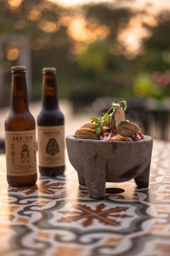 two bottles of beer and a bowl of food on a table at Hacienda Cenote San Ignacio in Chocholá