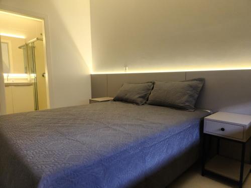 a bedroom with a bed with a blue comforter at Mar de ensueños in Florianópolis