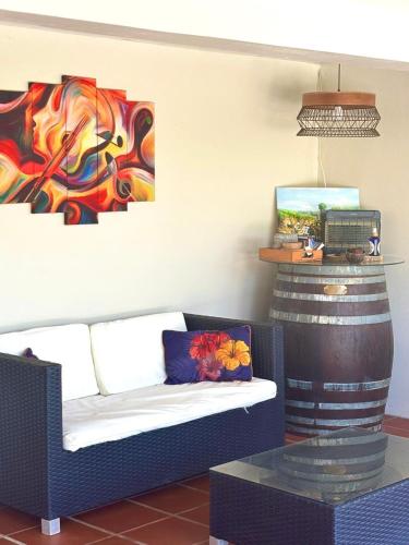 a living room with a couch and paintings on the wall at La cocoteraie in Barington