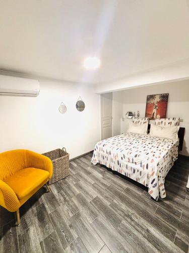 a bedroom with a bed and a chair at La cocoteraie in Barington