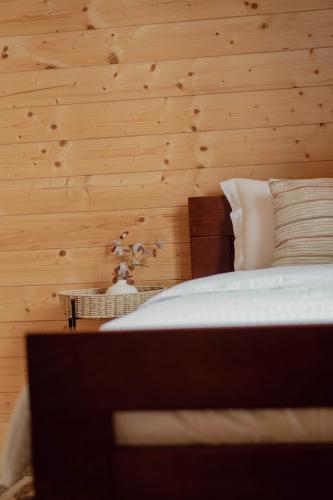 a bedroom with a bed and a wooden wall at Pino House Zlatibor-Tornik in Ribnica