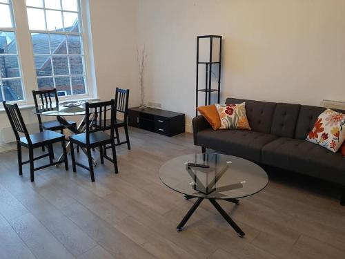 a living room with a couch and a table and chairs at Super Central 2bed Central Reading - free parking in Reading