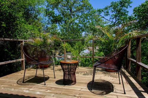 two chairs and a table on a wooden deck at Tiny Village Cartagena Boutique Resort in Tierra Bomba