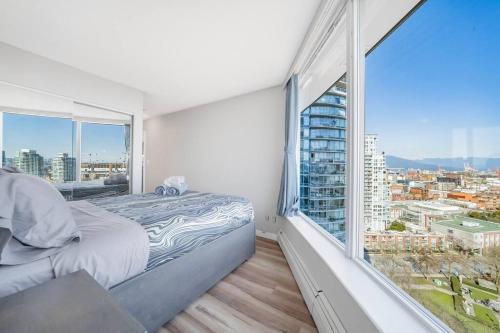 a bedroom with a bed and a large window at Beautiful Dt 3 Bed 2Bath Apat Free Parking & Pool in Vancouver