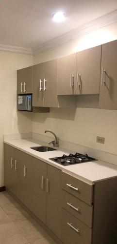 a kitchen with a sink and a stove and cabinets at DORAL SUITE ¡CERCA DEL AEROPUERTO! in Guayaquil
