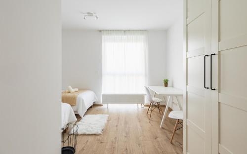 a white room with a bed and a table at BNB Urban Oasis Bajkalska in Bratislava