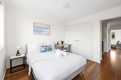 a white bedroom with a large white bed and a room at Luxe Double Room in Panania - Nearby Stations & Shops - Shared Bathroom in Panania