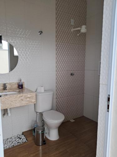 a bathroom with a toilet and a sink at Espaço Cris in Pindamonhangaba