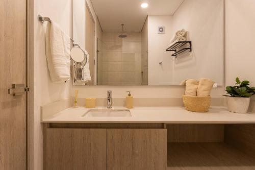 a bathroom with a sink and a mirror at Aparta suite Playa Bello Horizonte Santa Marta in Santa Marta