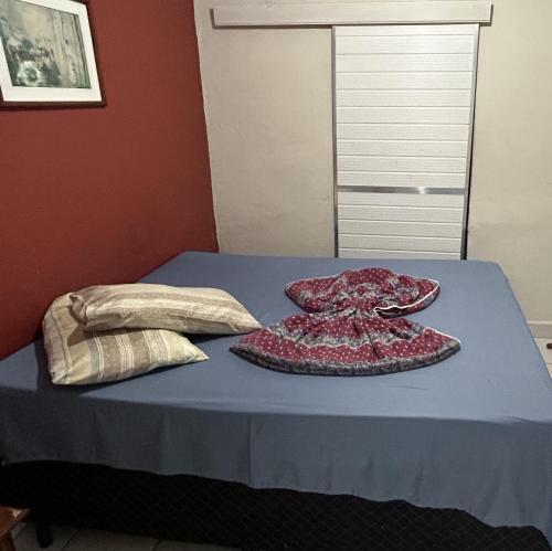 a bed with two pillows sitting on top of it at Pousada Orquidário in Santos